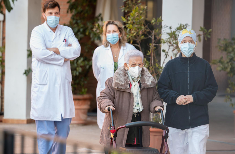  Araceli y Mónica, la residente más longeva de la Residencia de mayores Los Olmos y la sanitaria más joven, acompañadas de personal del geriátrico, tras recibir la segunda dosis de la vacuna Pfizer-BioNTech, en Guadalajara, Castilla-La Mancha. - RAFAEL MARTÍN - Europa Press 