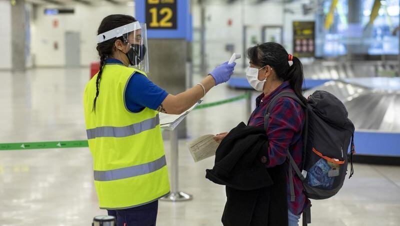  Una trabajadora toma la temperatura a una pasajera en el aeropuerto Adolfo Suarez Madrid-Barajas (Pablo Blazquez Dominguez : Getty) 