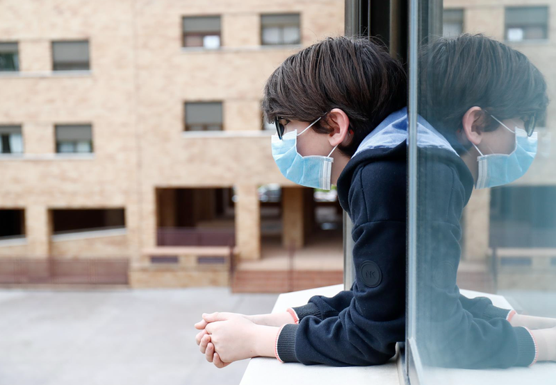  Archivo - Un niño con una mascarilla se asoma a la ventana de su casa. - Óscar J.Barroso - Europa Press - Archivo 