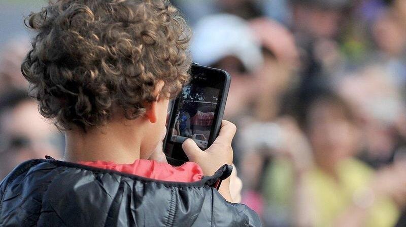  Niño con un teléfono móvil en el recreo. 