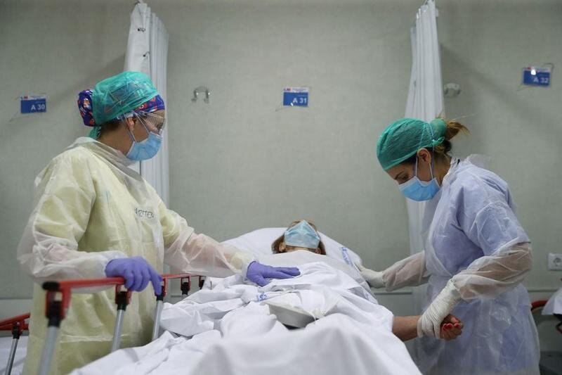 Healthcare workers in protective gear treat an elderly patient at the emergency room as the spread of the coronavirus disease (COVID-19) continues, at Infanta Sofia University hospital in Madrid, Spain, May 8, 2020. REUTERS/Susana Vera