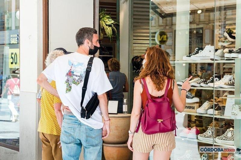  Varias personas observando el escaparate de una tienda de zapatos / Pilar Gázquez. 