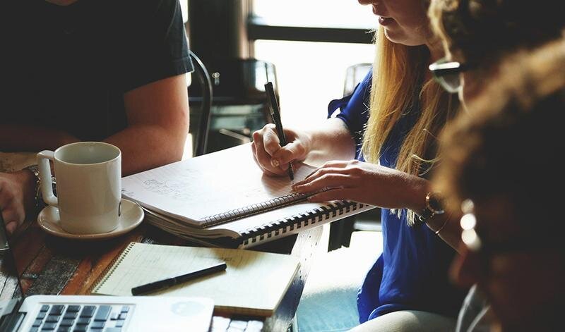  Una mujer empresaria toma notas en un cuaderno. 