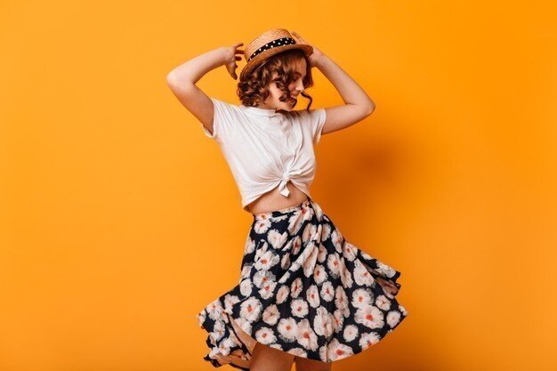  mujer-agraciada-falda-moda-bailando-manos-alto-foto-estudio-romantica-chica-rizada-divirtiendose-sobre-fondo-amarillo_197531-17485 