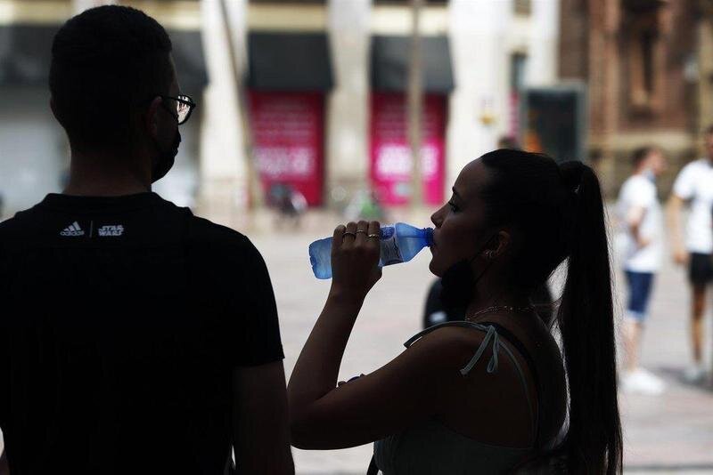  Varias personas intentan protegerse del calor en el día donde la capital andaluza se encuentra en aviso naranja por temperaturas que superarán los 40 grados en algunos puntos de la capital y la provincia a 12 de julio del 2021 en Málaga (Andalucía). - Álex Zea - Europa Press 