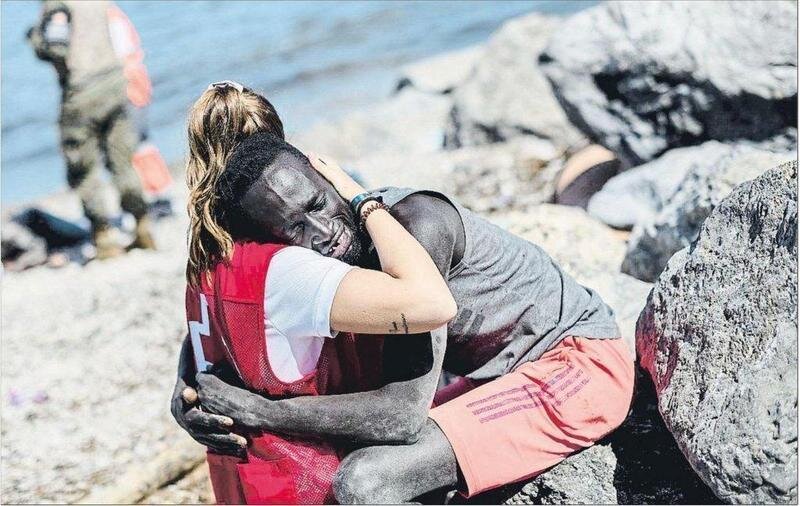  Luna, trabajadora de Cruz Roja consolando a un migrante que ha llegado a Ceuta / Twitter: @CruzRojaEsp 