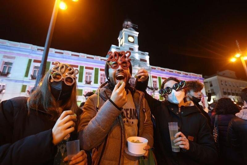 <p> Personas comiendo las uvas en la puerta del sol </p>