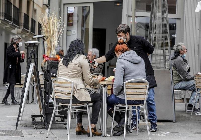 <p> Un camarero atiende a dos clientas en una terraza el primer día de la apertura de la hostelería. EP </p>