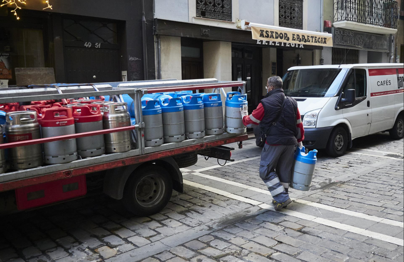 <p> Un repartidor deja bombonas de butano a un bar en Pamplona. Fuente: Europa Press </p>