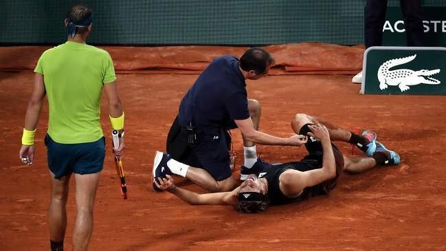 <p> Nadal acudiendo a ver el estado de Zverev lesionado en el suelo </p>