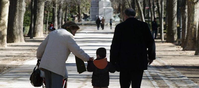 <p> Dos jubilados paseando junto a su nieto </p>