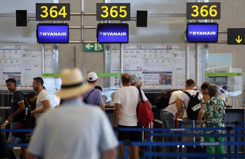 <p> Cientos de turistas hacen colas en los puestos de embarque de Ryanair, en el Aeropuerto Costa del Sol </p>