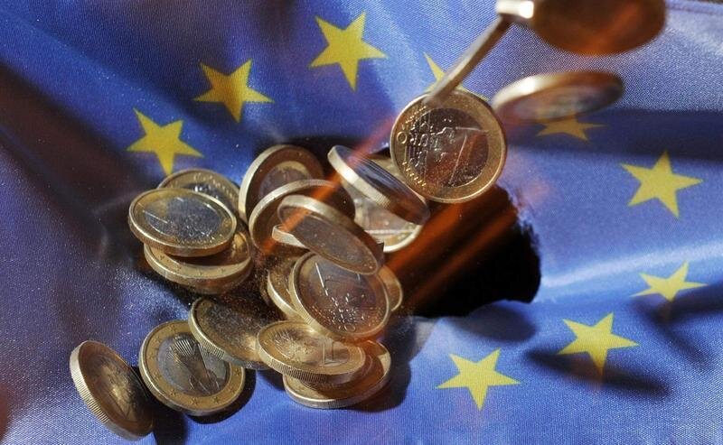 <p> Monedas de un euro caen sobre una bandera de la UE. El producto interior bruto de la Unión Europea se contrajo un 3,5 % en los tres primeros meses del año, según una primera estimación de Eurostat - picture alliance / Uli Deck/dpa </p>