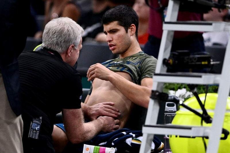 <p> Carlos Alcaraz siendo atendido del abdomen en plena pista </p>