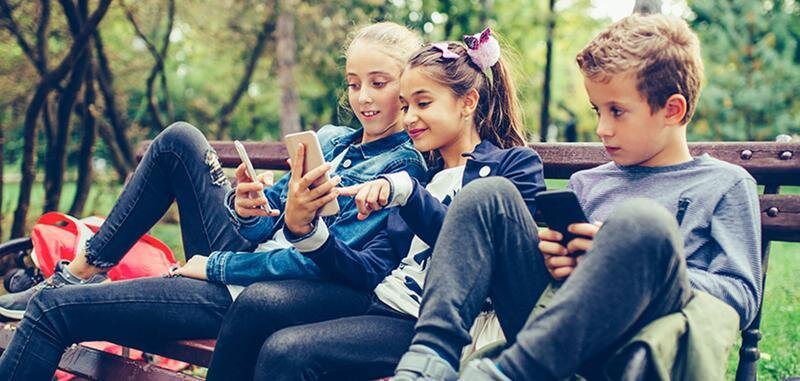  Niños con teléfonos en el parque 