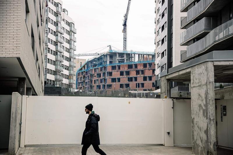  Un hombre pasa por delante de una obra, en construcción, parada por falta de suministros como el hormigón, en Vallecas 