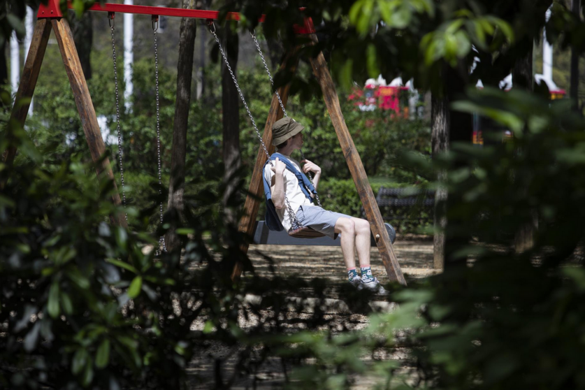  Un turista vestido con ropa veraniega sentado en un columpio. - María José López - Europa Press 