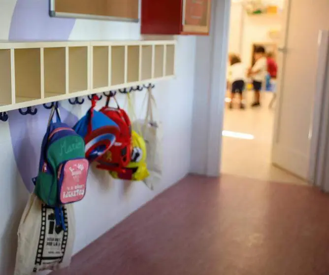  Varias mochilas en una percha de un aula de 0 a 3 años de un colegio 