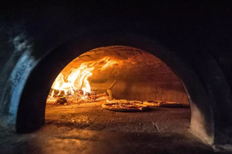  Pizza cocinándose en un horno de leña 