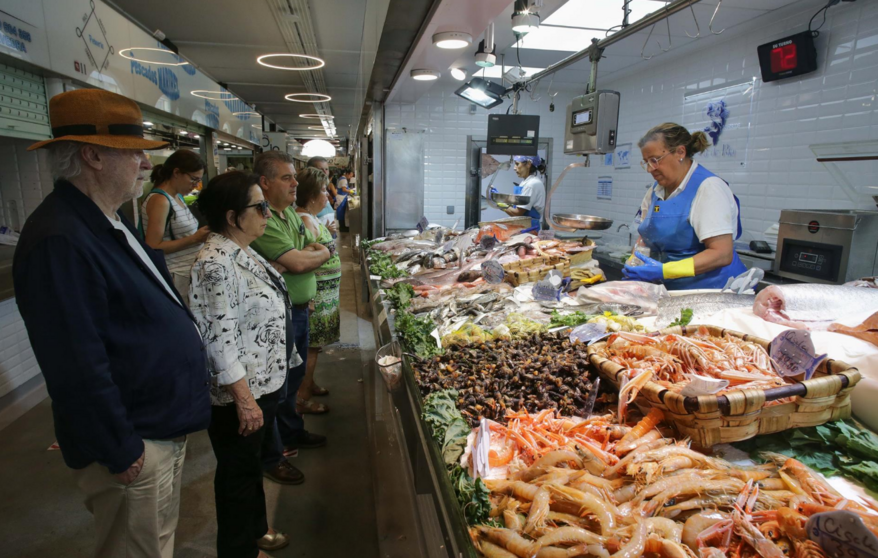  Varias personas comprando alimentos en un mercado 