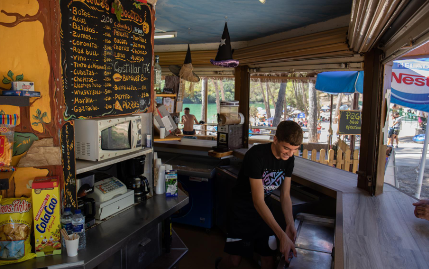  Un joven trabajando en un quiosco de bebida y comida 