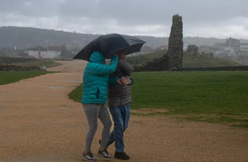  Dos personas se protegen de la lluvia con un paraguas 