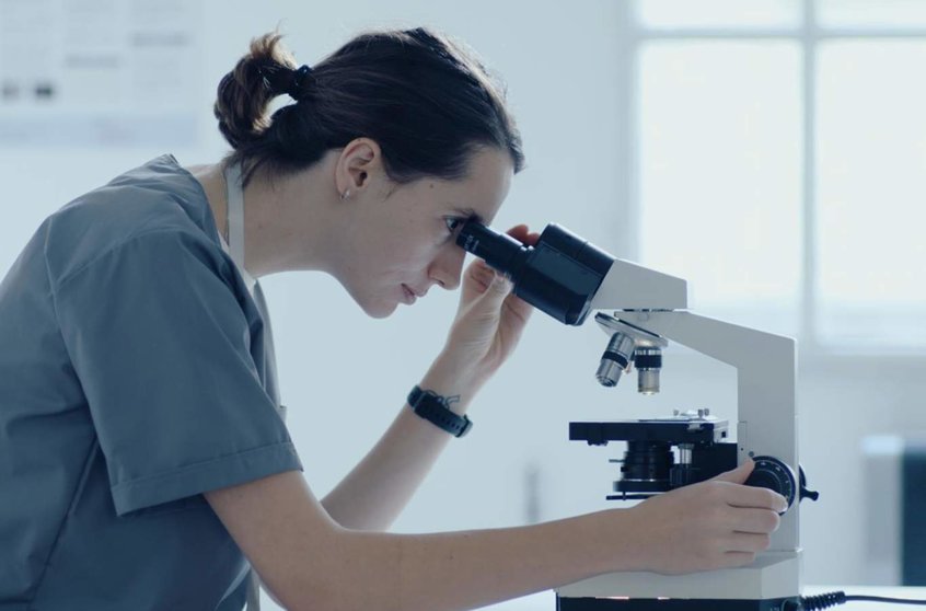  Investigadora mirando por un microscopio - MICIU 