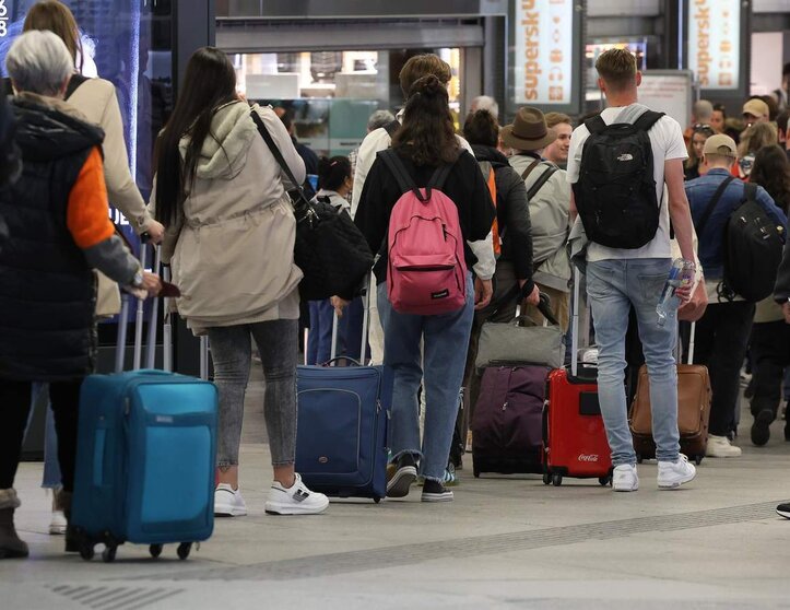  Numerosas personas con maletas salen de viaje en la estación Almudena Grandes-Atocha Cercanías | EP 