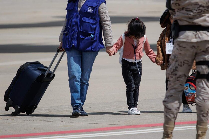  Una niña procedente de Siria de la mano de una trabajadora de una organización a su llegada a la base aérea de Torrejón de Ardoz, a 19 de mayo de 2023 