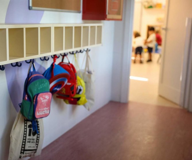  Varias mochilas en una percha de un aula 