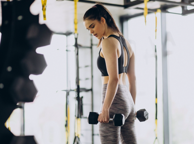  Archivo - Mujer joven haciendo deporte en un gimnasio levantando pesas. - QERES - Archivo 