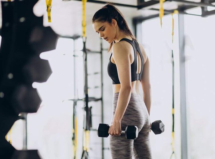  Archivo - Mujer joven haciendo deporte en un gimnasio levantando pesas. - QERES - Archivo 