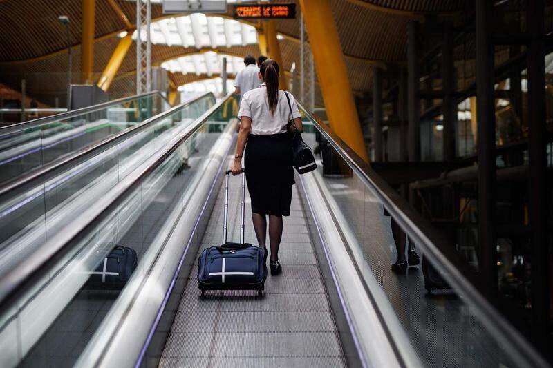  Una azafata en las escaleras mecánicas de la Terminal 4 (T4) del aeropuerto Adolfo Suárez Madrid-Barajas, a 8 de junio de 2022, en Madrid 