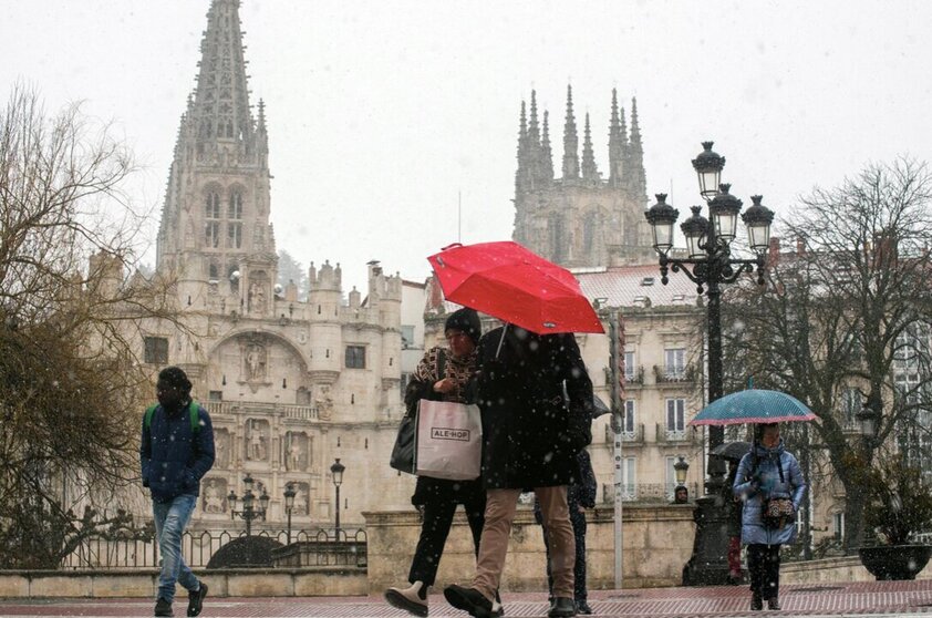  Varias personas caminan por la calle mientras nieva, a 23 de febrero de 2023, en Burgos, Castilla y León (España). - Tomás Alonso - Europa Press 